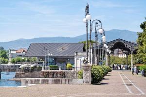 a street light in front of a building next to a body of water at Appartamento Vista Lago Ghiffa in Ghiffa