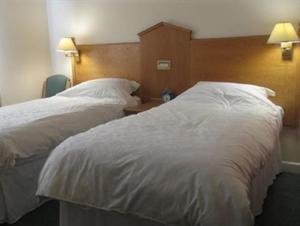 two beds in a hotel room with white sheets at Hazelwood Guest House in Bridgend +4 photos
