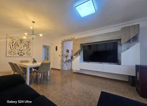 a living room with a large television and a table at Villa Flores in Alicante