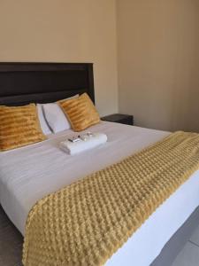 a bedroom with a large bed with two towels on it at Jate Guest House in Maseru