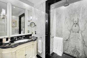 a bathroom with a sink and a shower at The Lanesborough, Oetker Hotels in London +104 photos