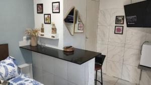 a kitchen with a black counter top and a shower at POUSADA MEGA in Marataizes +13 photos