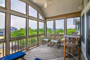 a screened in porch with windows and a table and chairs at 2433 - Bella Bay in Duck