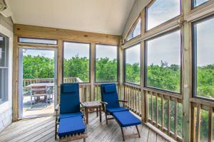 a screened in porch with blue chairs and a table at 2433 - Bella Bay in Duck