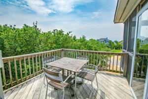 a wooden deck with a table and chairs on it at 2433 - Bella Bay in Duck +50 photos