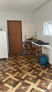 a kitchen with a wooden floor and a refrigerator at Kit net individual in Araguaína