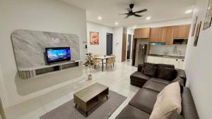 a living room with a couch and a tv on a wall at The Podium, Kuching in Kuching