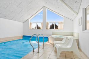 a swimming pool with a table and chairs in a house at 2002-Romo-Juvrevej-51b in Høm