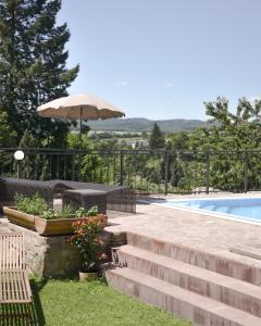 a patio with an umbrella and stairs next to a pool at VAPARTMANY in Plumlov