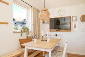 a dining room with a table and a clock on the wall at 13504-Vig-Lyngvej-107-5 in Vig +7 photos