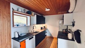 a kitchen with black and white appliances and a window at Idyllic Vacation Home with a Breathtaking View in Bøur