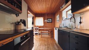a kitchen with black cabinets and a wooden ceiling at Idyllic Vacation Home with a Breathtaking View in Bøur