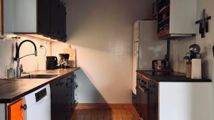 a kitchen with black cabinets and a white refrigerator at Idyllic Vacation Home with a Breathtaking View in Bøur
