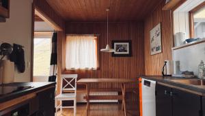 a kitchen with a table and a dining room at Idyllic Vacation Home with a Breathtaking View in Bøur +12 photos