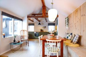 a kitchen and dining room with a wooden table and chairs at 13345-1-Vig-Poppelvej-21 in Vig
