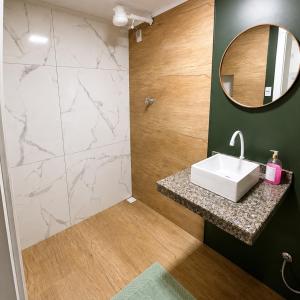 a bathroom with a sink and a mirror at Hotel Presidente Ibirubá in Ibirubá