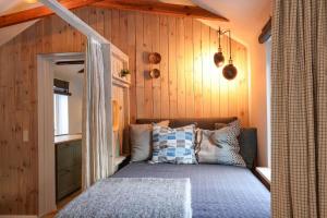a bedroom with a bed in a room with wooden walls at 13345-1-Vig-Poppelvej-21 in Vig