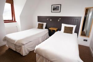 A bed or beds in a room at The Arch Inn