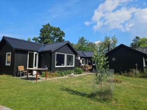 a black house with a picnic table in a yard at 13345-1-Vig-Poppelvej-21 in Vig