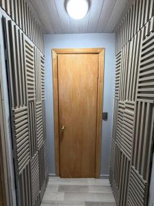 a hallway with a wooden door in a room at departamento de interior Pucón in Pucón