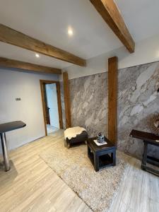 a room with a stone wall with a bench and a table at departamento de interior Pucón in Pucón