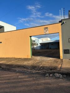 an orange building with a large doorway into a garage at Kit net individual in Araguaína