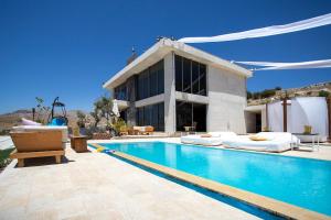 a villa with a swimming pool in front of a building at Hacienda 888 in Ḑahr al Baydar