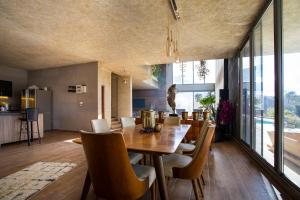 a dining room with a wooden table and chairs at Hacienda 888 in Ḑahr al Baydar