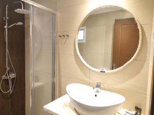 a bathroom with a sink and a shower and a mirror at Hotel Alexandros II in Toroni +62 photos