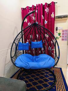 a swing chair with blue pillows in a room at Cozystayz NuNa in Sitiawan +54 photos