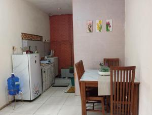 a kitchen with a refrigerator and a table and chairs at Thian Homestay in Batukaras