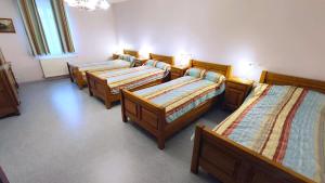 a group of four beds in a room at La ferme de la fontaine in Douzy