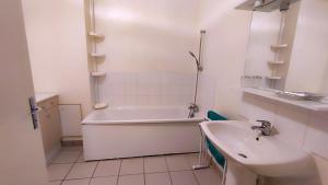 a white bathroom with a tub and a sink at La ferme de la fontaine in Douzy +14 photos