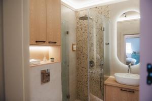 a bathroom with a sink and a glass shower at Central Premium Suites in Plovdiv +236 photos