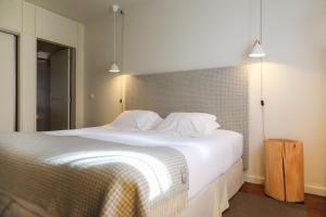 a bedroom with a large white bed with two pillows at Casas do Soito in Seia +30 photos