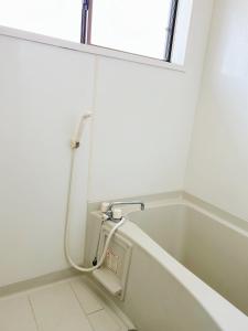 a white bath tub in a bathroom with a window at 田園の宿 in Takehanachō +13 photos