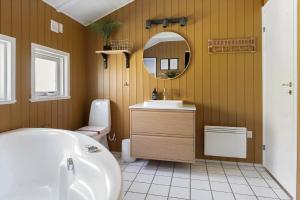a bathroom with a sink and a toilet and a mirror at 2556-Romo-Kromosevej-15 in Høm +32 photos