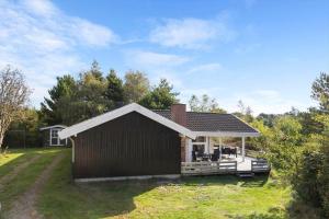 a small house with a deck in a yard at 2556-Romo-Kromosevej-15 in Høm