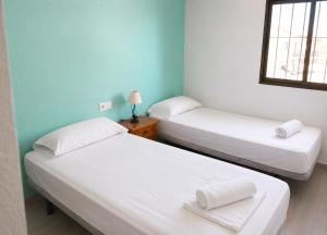 two twin beds in a room with a window at TARONGERS 7 in Peniscola