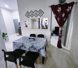 a dining room with a table and some chairs at Cozystayz NuNa in Sitiawan