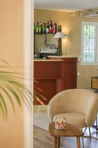 a living room with a chair and a table at Hôtel Beau Site - Cap d'Antibes in Antibes