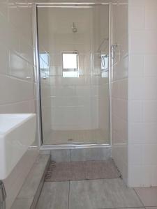 a bathroom with a shower with a glass door at Jate Guest House in Maseru +17 photos