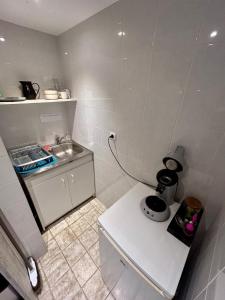 a small white kitchen with a sink and a counter at Studio proche RN145 Chez Greg in Saint-Sulpice-le-Guérétois