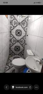 a bathroom with a toilet and a sink at Suítes em Parintins in Parintins