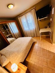 a bedroom with a bed and a desk and a television at Studio proche RN145 Chez Greg in Saint-Sulpice-le-Guérétois