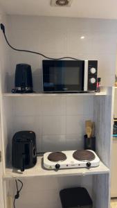 a microwave sitting on top of a stove in a kitchen at Studio proche RN145 Chez Greg in Saint-Sulpice-le-Guérétois