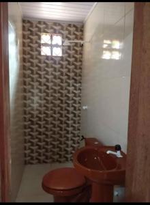 a bathroom with a toilet and a sink at Suítes em Parintins in Parintins