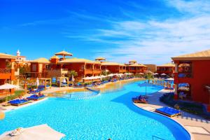 a pool at a resort with chairs and umbrellas at Pickalbatros Alf Leila Wa Leila Resort - Neverland Hurghada in Hurghada