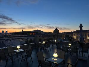 a rooftop patio with tables and chairs at sunset at Sarajevo Center Point in Sarajevo
