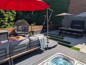 a hot tub on a deck with a red umbrella at Tomorrowland Boom in Boom